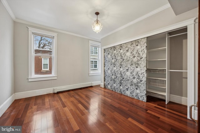 spare room with a chandelier, a baseboard radiator, ornamental molding, and hardwood / wood-style floors