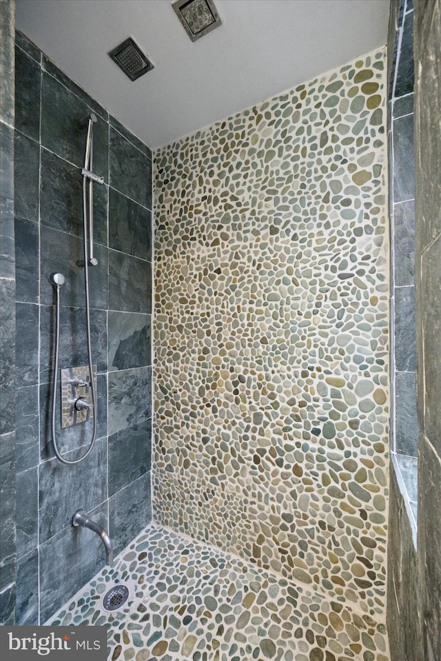 bathroom featuring visible vents and tiled shower