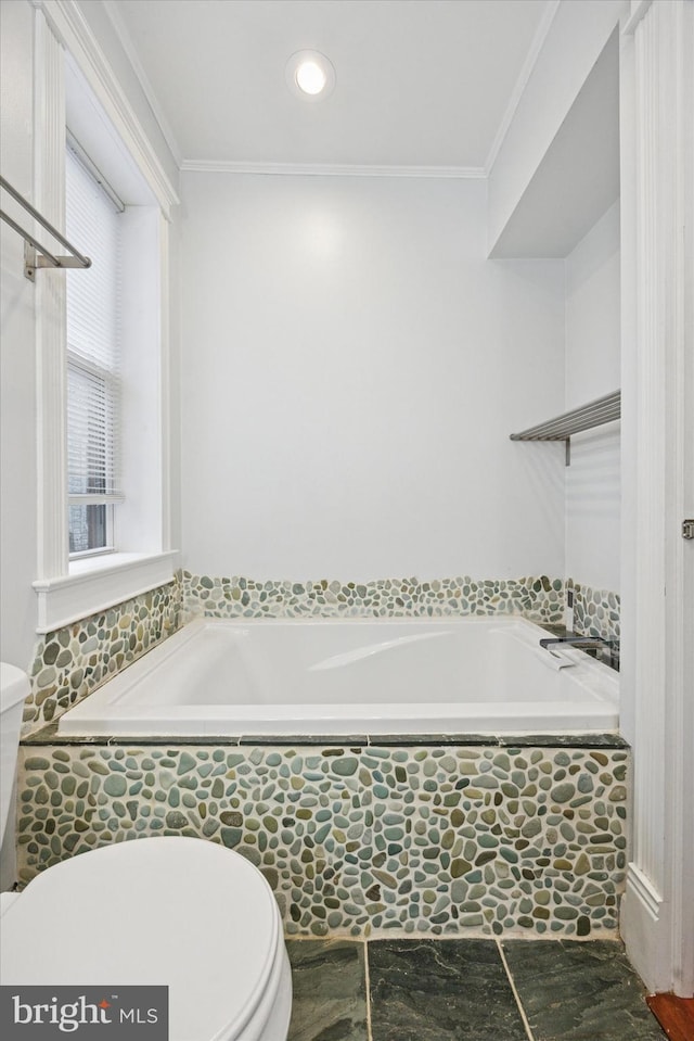 bathroom featuring ornamental molding, toilet, and a bath