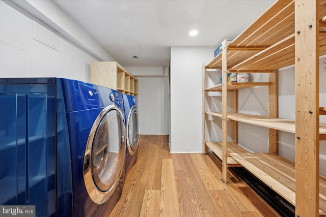 washroom with washer and dryer, laundry area, and wood finished floors