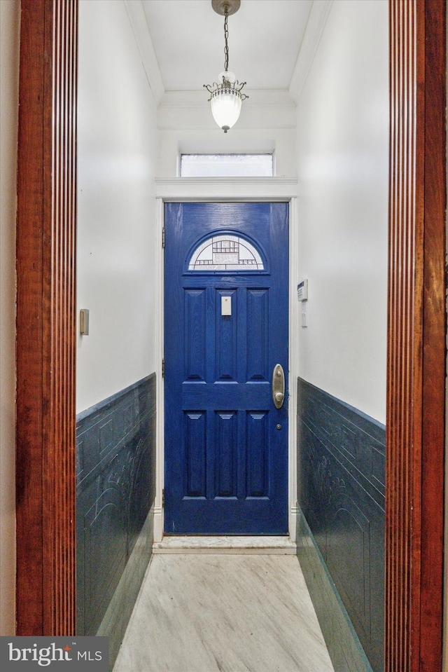 foyer entrance featuring wainscoting, wood finished floors, and crown molding