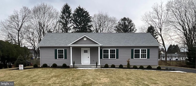 view of front of home with a shingled roof and a front yard