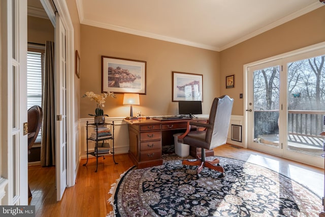 office with light wood-style floors, ornamental molding, wainscoting, and a decorative wall