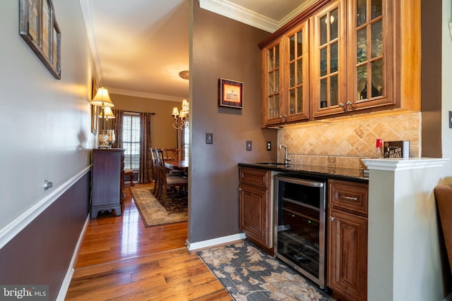 bar featuring beverage cooler, backsplash, crown molding, and hardwood / wood-style floors