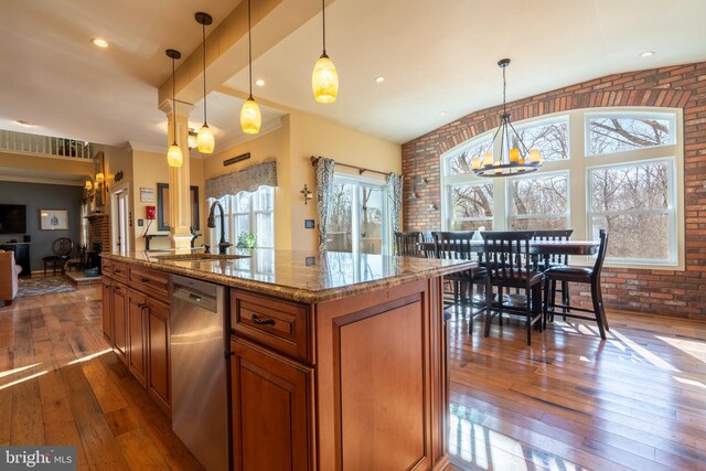 kitchen featuring brick wall, dishwasher, decorative columns, brown cabinets, and a sink