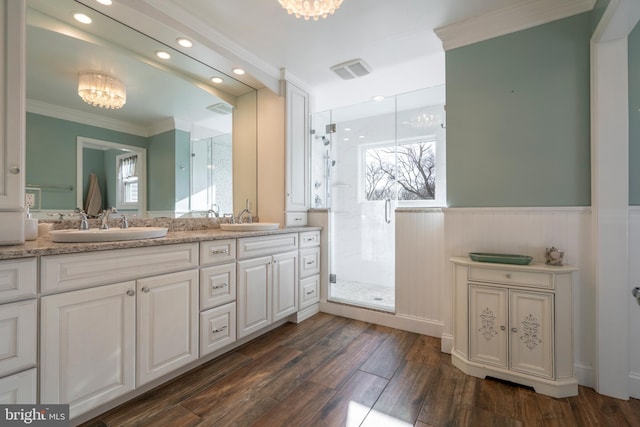 bathroom featuring a stall shower, wood finished floors, and a sink