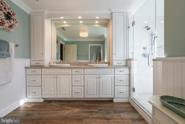 full bathroom featuring a sink, ornamental molding, and a shower stall