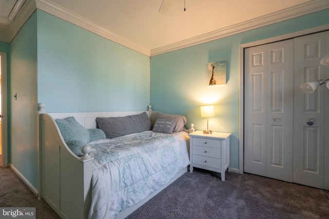 carpeted bedroom with a closet, crown molding, and baseboards