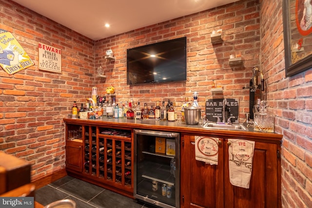 bar with a bar, beverage cooler, and brick wall