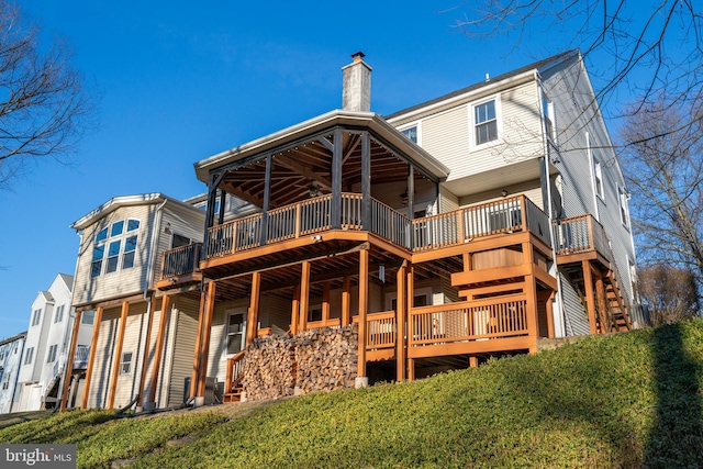 rear view of house with a deck and a chimney