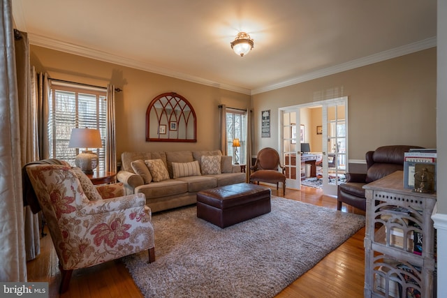 living area with a wealth of natural light, wood-type flooring, and crown molding