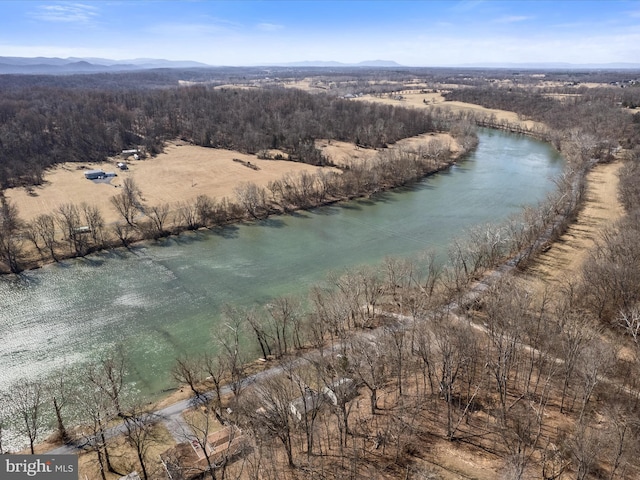 aerial view with a wooded view and a water and mountain view