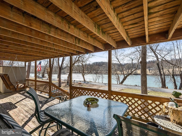 deck featuring outdoor dining space and a water view