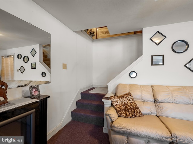 carpeted living area with stairway and baseboards