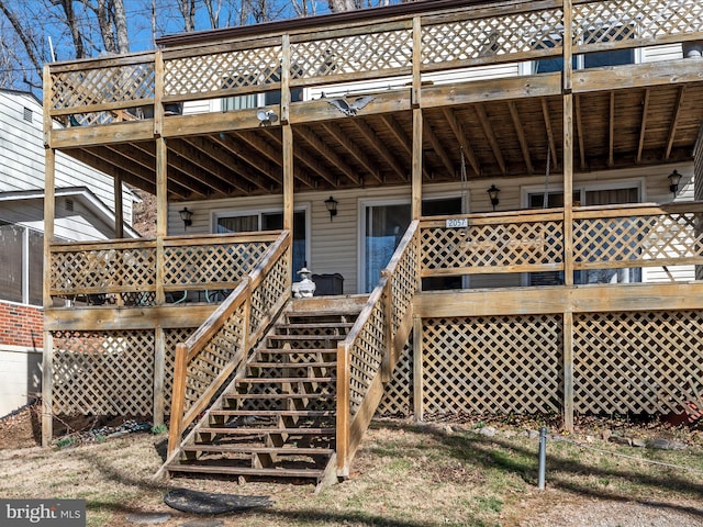 back of property featuring stairway and a deck