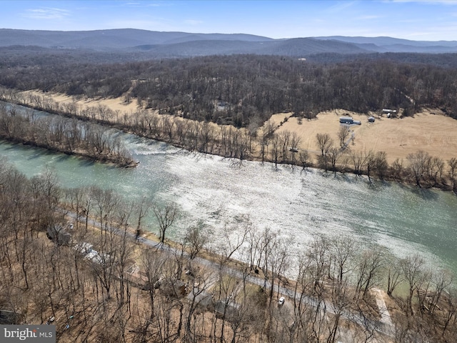 drone / aerial view with a wooded view and a water and mountain view