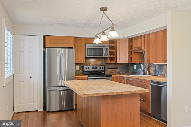 kitchen featuring a sink, appliances with stainless steel finishes, dark wood-style flooring, and wood counters