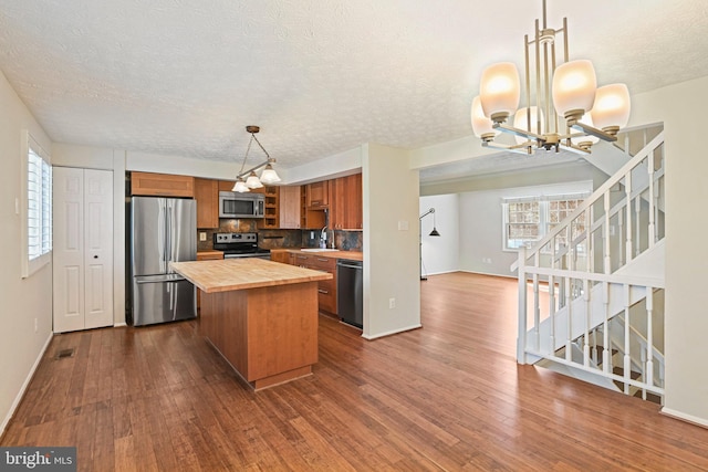 kitchen with brown cabinets, stainless steel appliances, dark wood-type flooring, a sink, and butcher block countertops