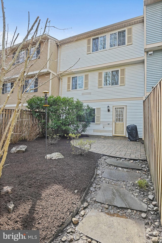 back of property featuring fence and a patio