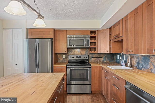 kitchen featuring stainless steel appliances, a sink, wood counters, dark wood-style floors, and open shelves