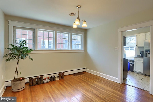 dining area featuring visible vents, plenty of natural light, an inviting chandelier, and wood finished floors