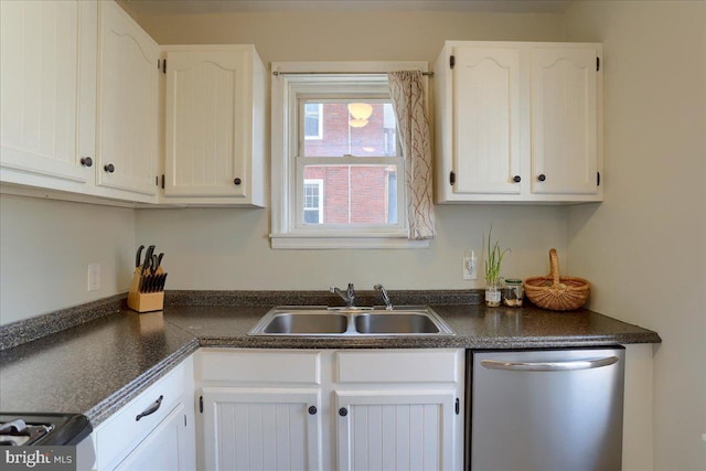 kitchen featuring dark countertops, dishwasher, white cabinetry, and a sink