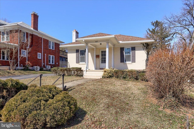 view of front of house with stucco siding, a porch, and a chimney