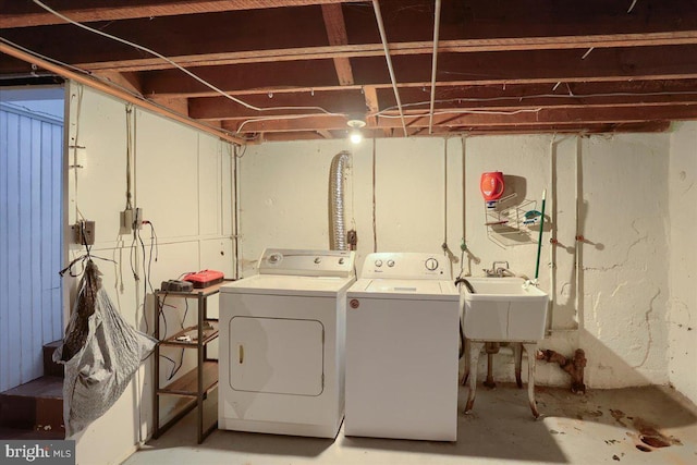 laundry room with a sink, laundry area, and washer and clothes dryer