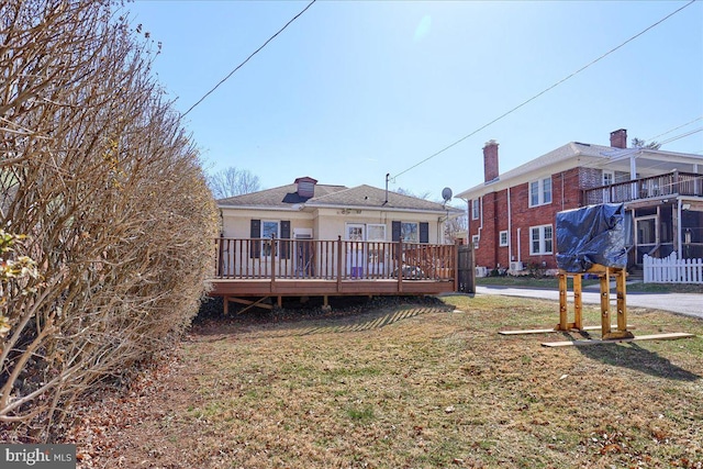 rear view of property with a lawn and a wooden deck