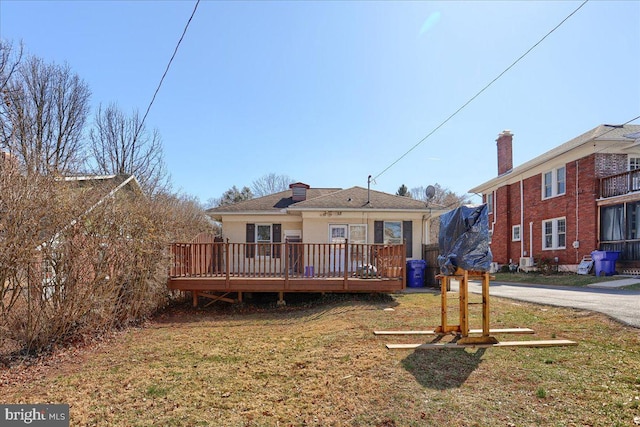 rear view of house with a wooden deck and a yard