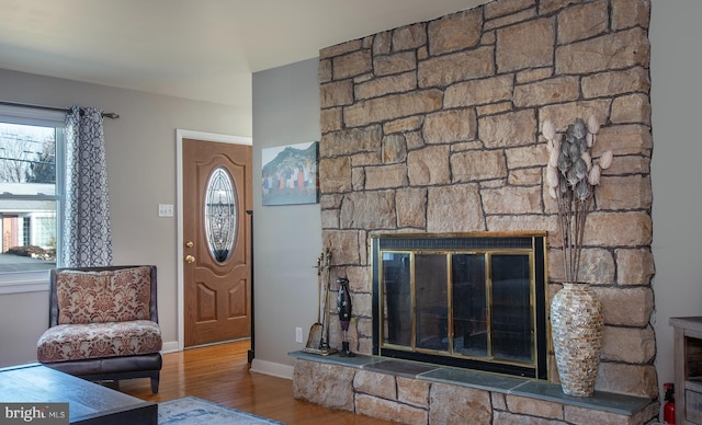 entrance foyer with a fireplace, baseboards, and wood finished floors