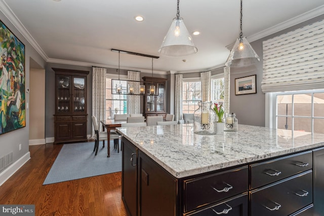 kitchen with dark wood-style floors, hanging light fixtures, baseboards, and crown molding