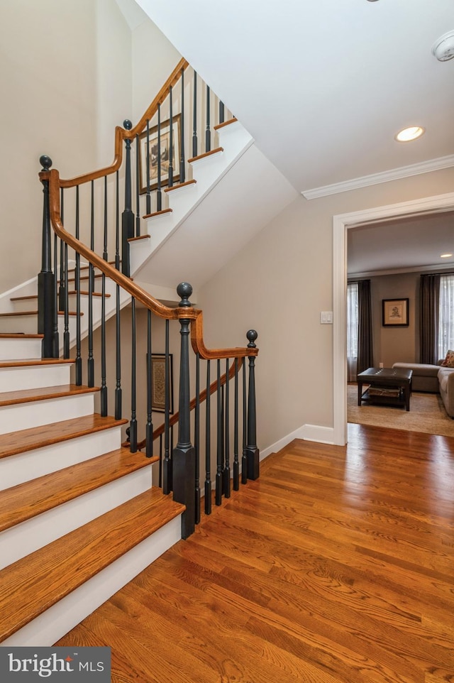 stairs featuring crown molding, baseboards, wood finished floors, and recessed lighting