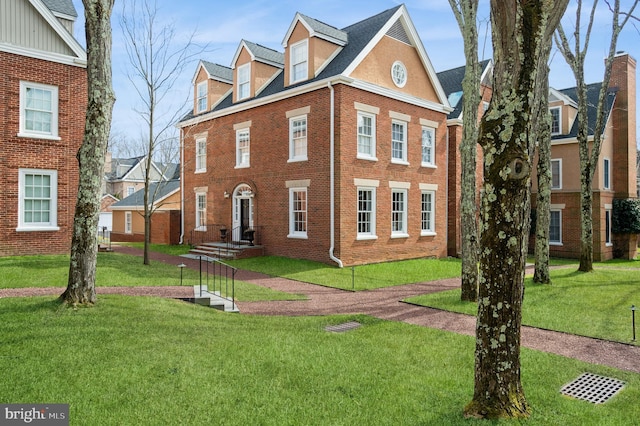 colonial inspired home with a front lawn and brick siding