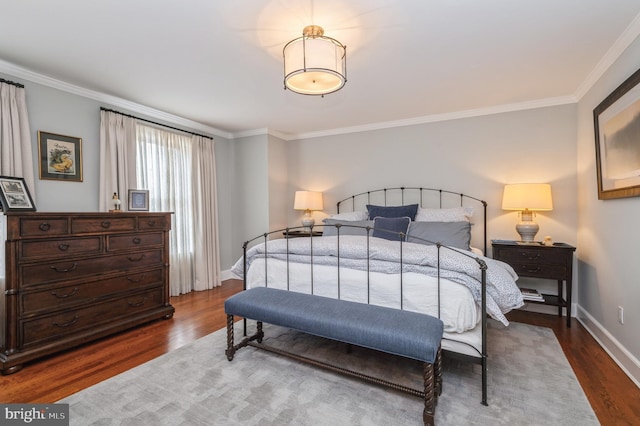 bedroom featuring crown molding, baseboards, and wood finished floors