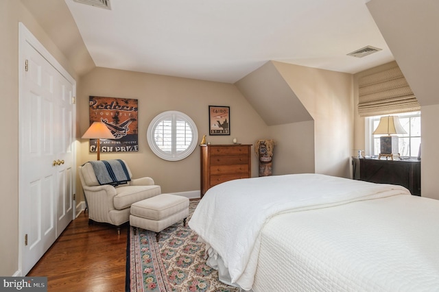 bedroom featuring lofted ceiling, visible vents, and wood finished floors