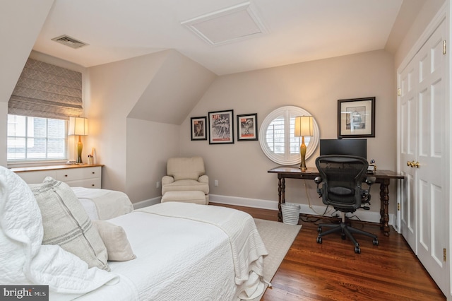 bedroom with dark wood-type flooring, attic access, multiple windows, and visible vents