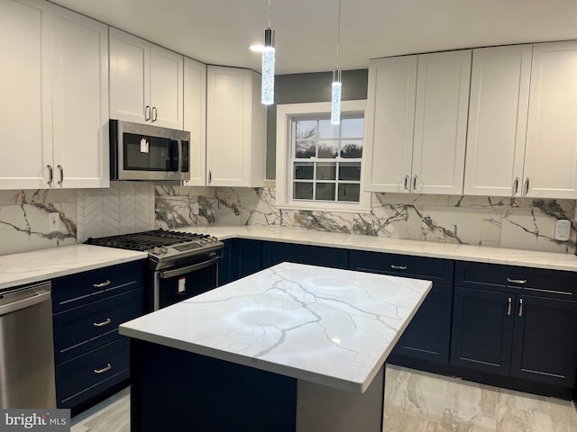 kitchen featuring stainless steel appliances, backsplash, a kitchen island, and white cabinetry