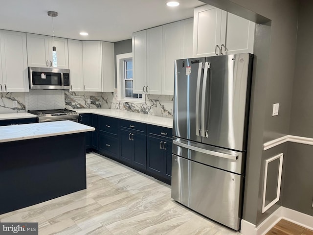 kitchen with stainless steel appliances, white cabinetry, decorative backsplash, light stone countertops, and pendant lighting