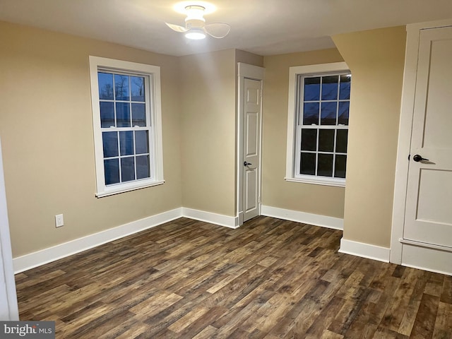 interior space with dark wood-type flooring and baseboards