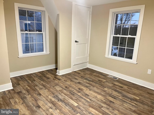 unfurnished bedroom with visible vents, dark wood finished floors, and baseboards