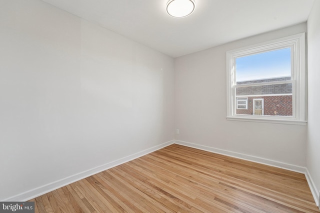 unfurnished room featuring baseboards and light wood finished floors