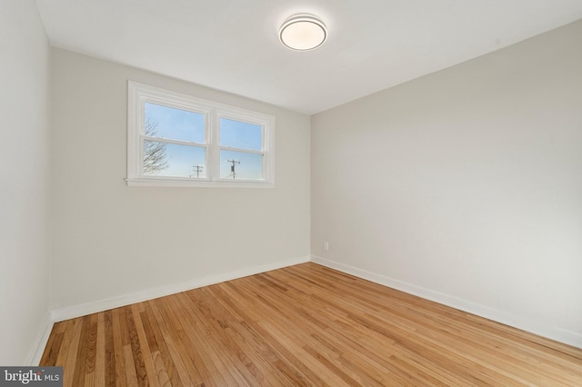 unfurnished room featuring hardwood / wood-style flooring and baseboards