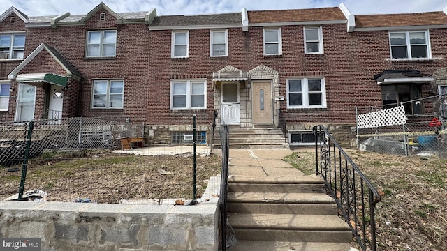 multi unit property featuring brick siding and fence