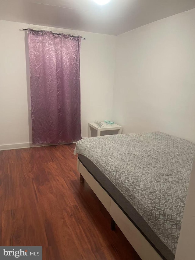 bedroom with baseboards and wood finished floors