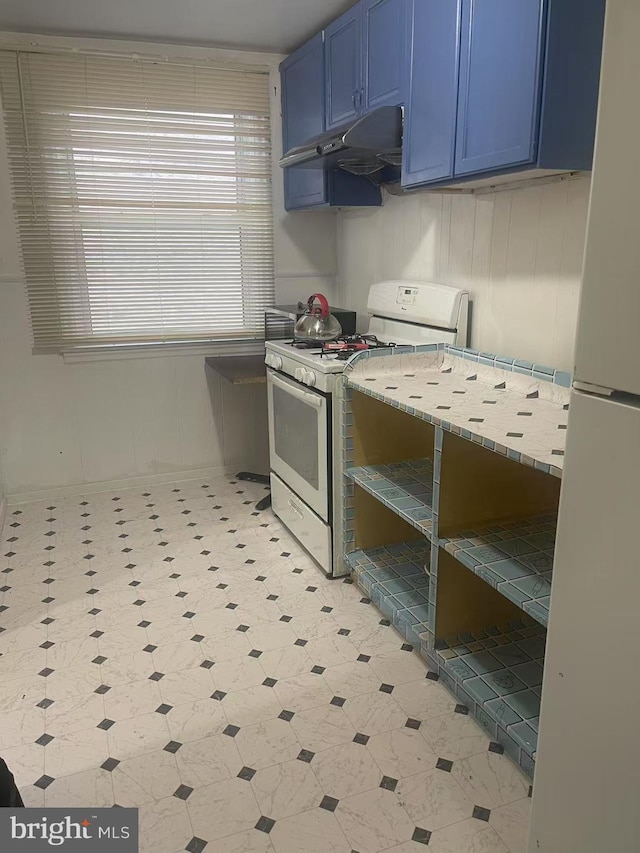 kitchen with white appliances, light floors, blue cabinetry, light countertops, and under cabinet range hood