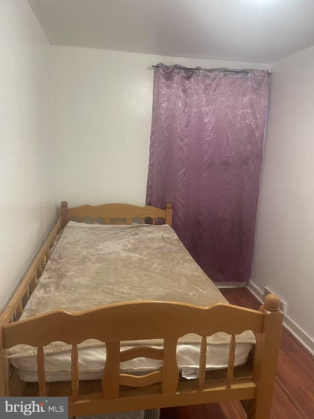 bedroom featuring baseboards and wood finished floors