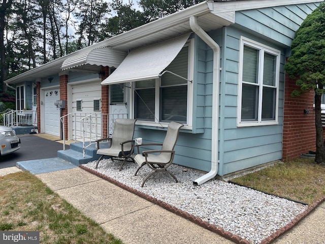 view of side of home with aphalt driveway and an attached garage