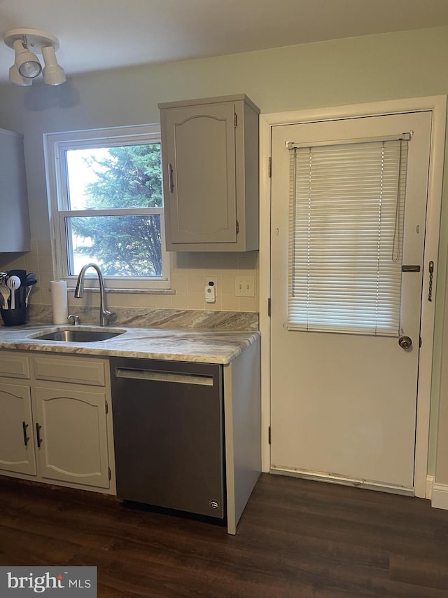 kitchen featuring a sink, dark wood-style flooring, decorative backsplash, and stainless steel dishwasher