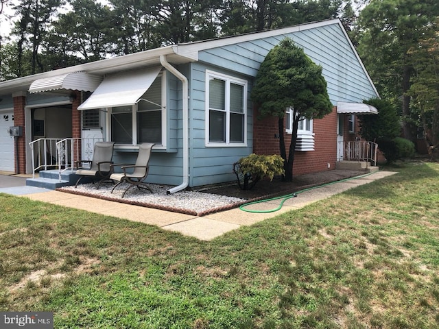 view of front of house featuring brick siding and a front yard